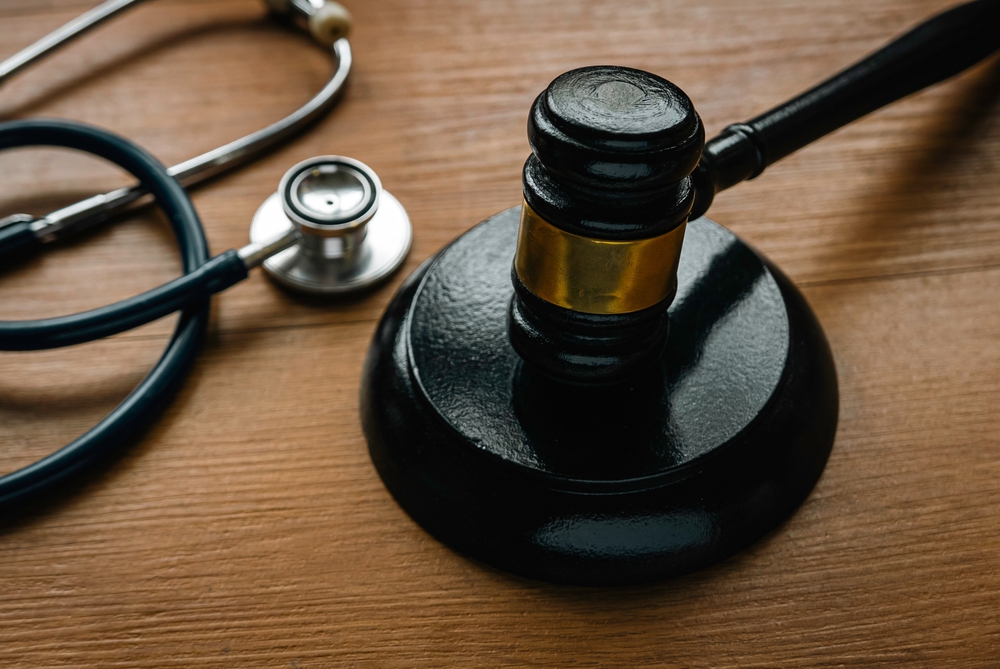 A judge’s gavel and stethoscope on a wooden desk, representing the link between legal claims and medical evidence after a bicycle accident in Clinton, Massachusetts.