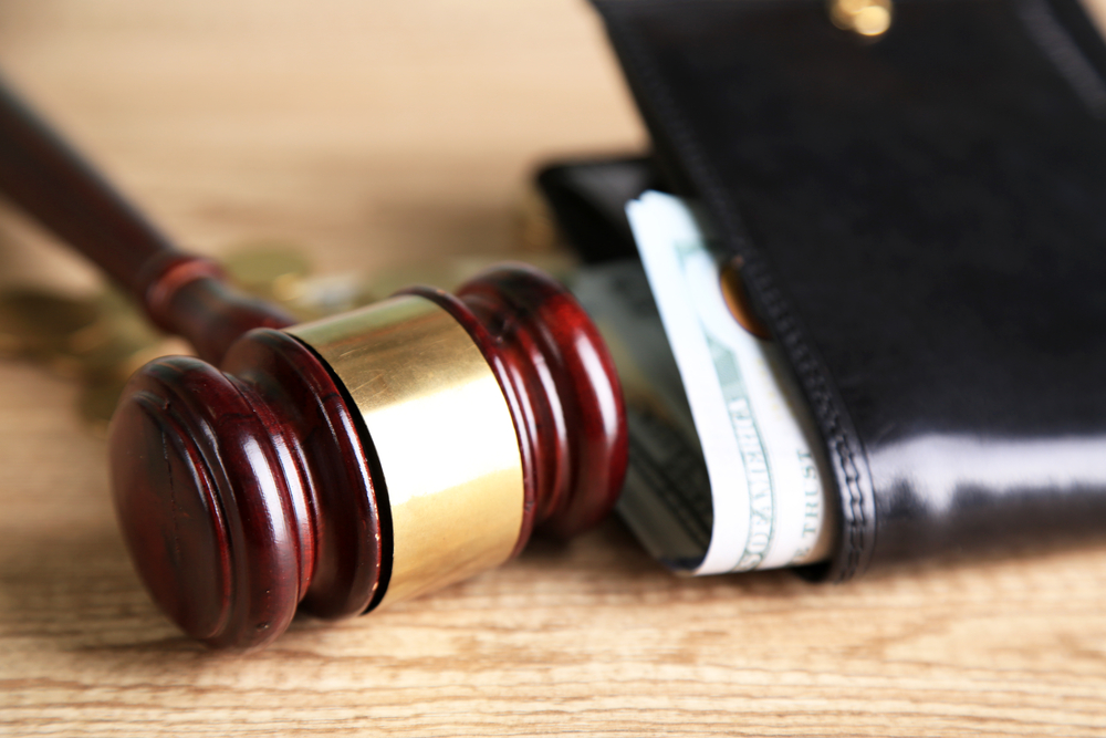 Gavel next to a wallet with cash representing compensation in a personal injury case