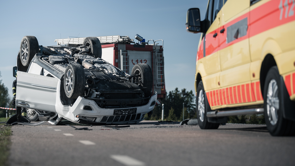 Rollover vehicle accident scene involving catastrophic injuries and emergency responders